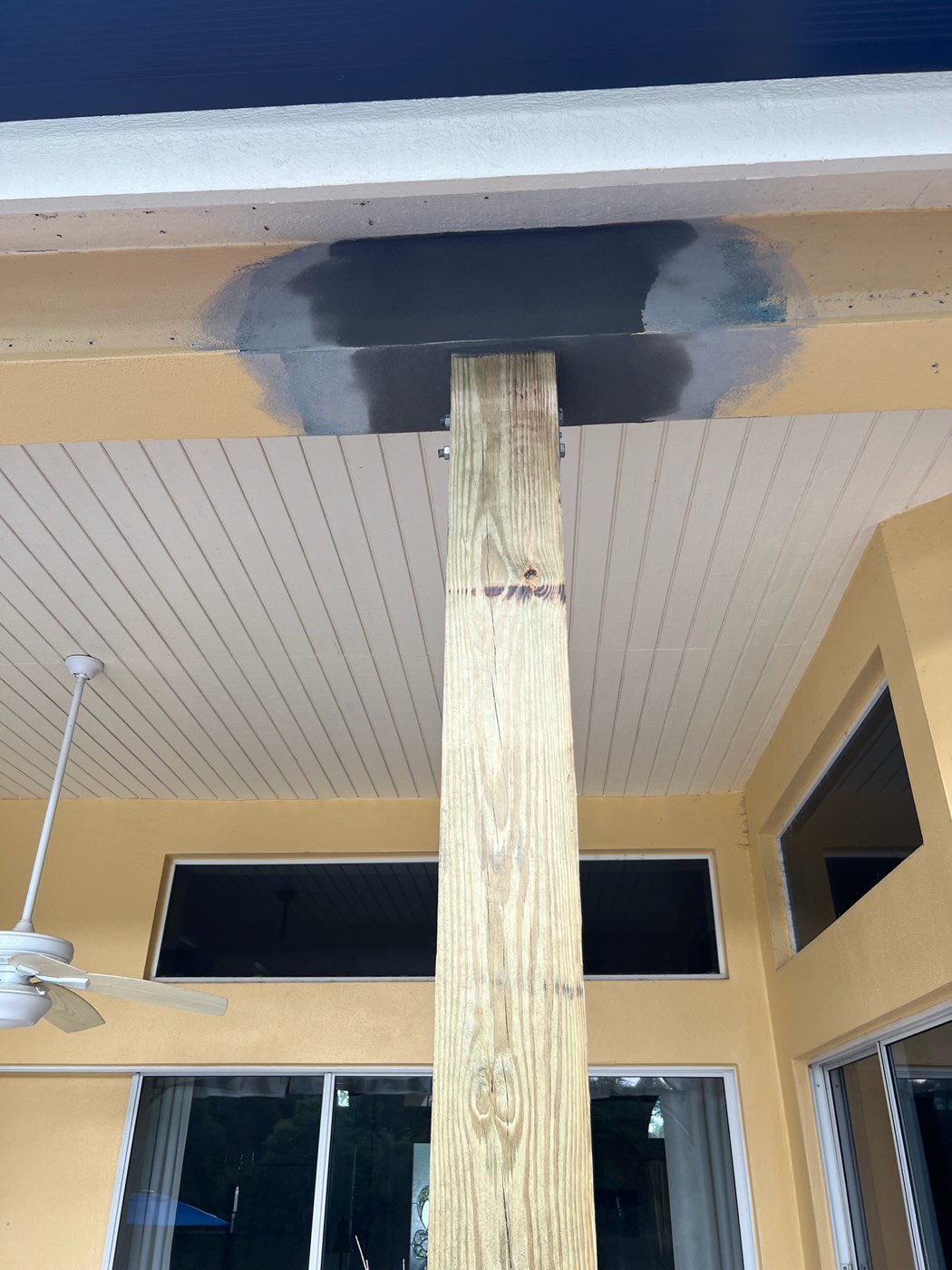 The beam above the porch post patched with new stucco