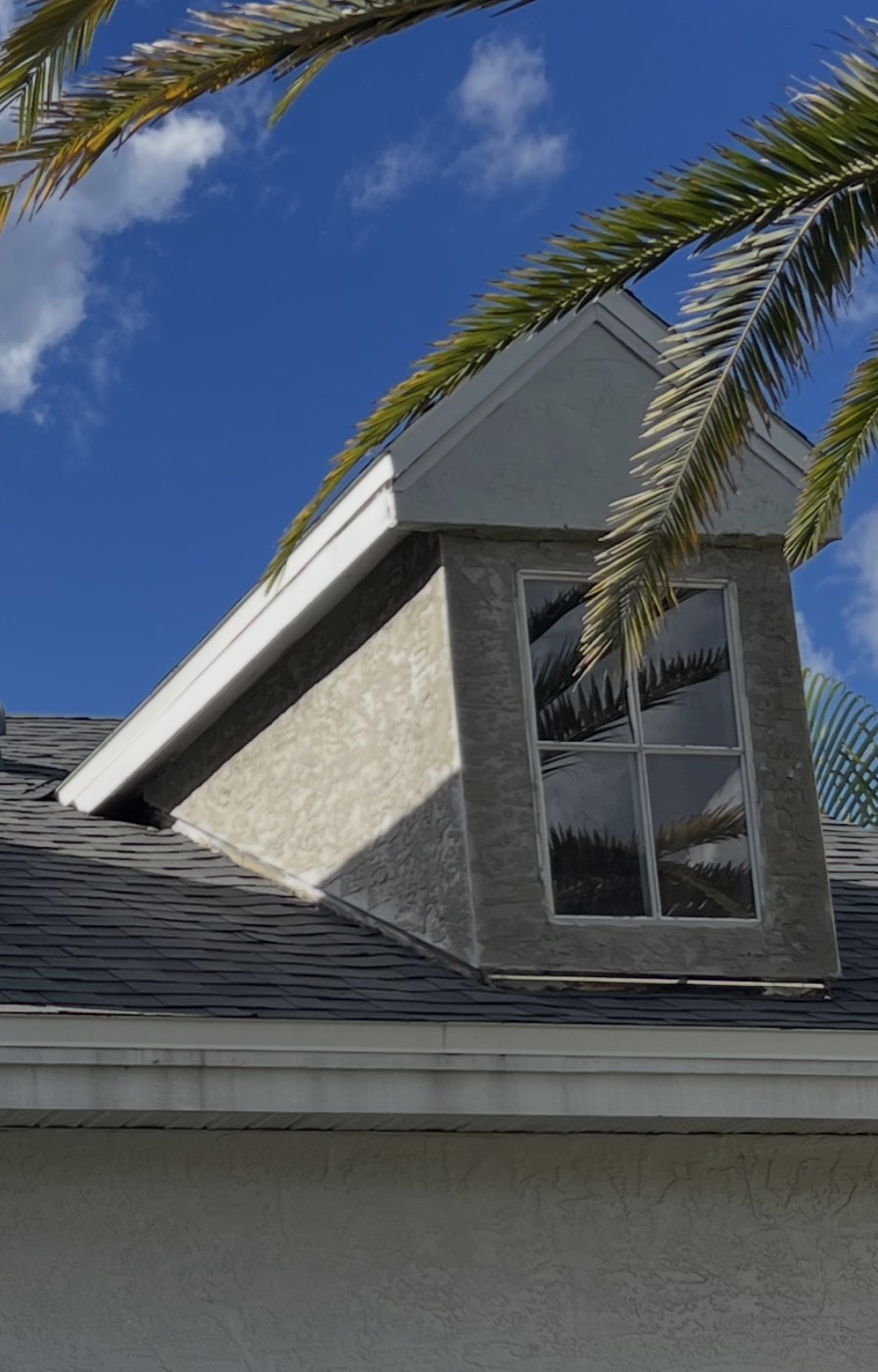 The finished dormer with fresh stucco